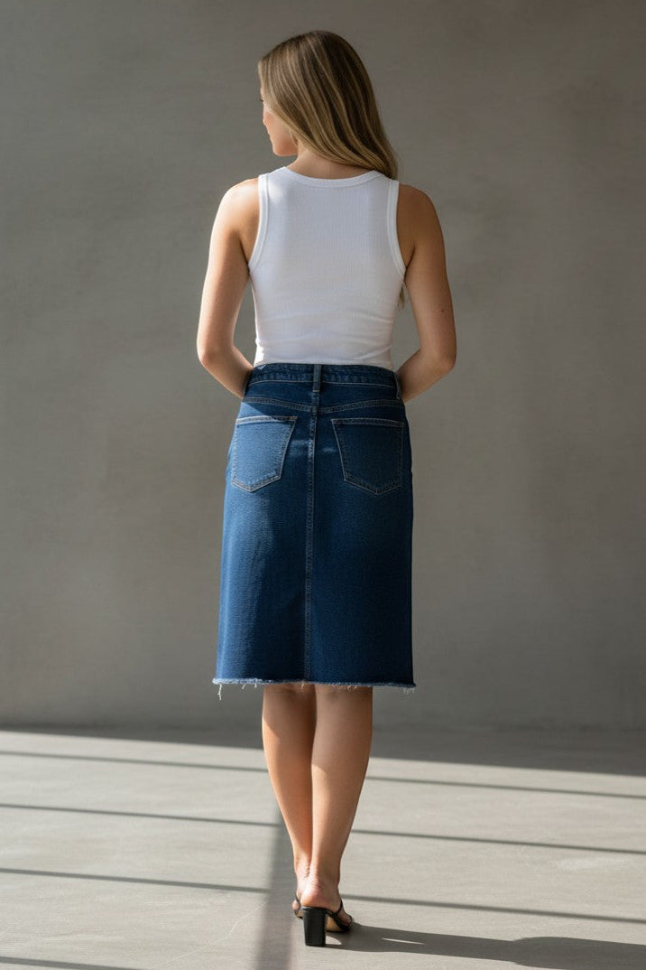 PQ Collection dark wash denim skirt with frayed hem, classic length, cotton blend with stretch and functional pockets.