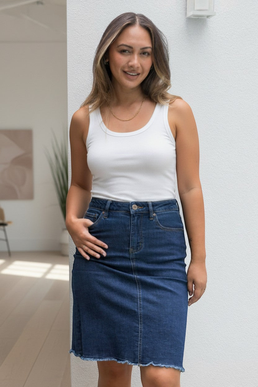 PQ Collection dark wash denim skirt with frayed hem, classic length, cotton blend, functional pockets.